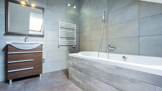 Bathroom with free standing bath on dark tiled floor