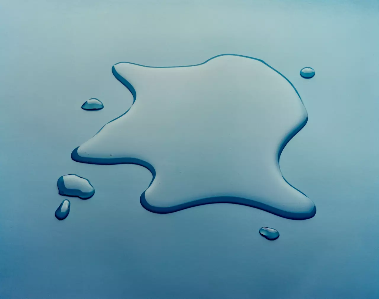 Large and small droplets of 561 Silicone Transformer Fluid on reflective "mirror" surface.