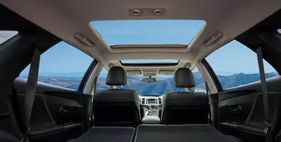 View of car interior from backseat looking forward to mountains ahead