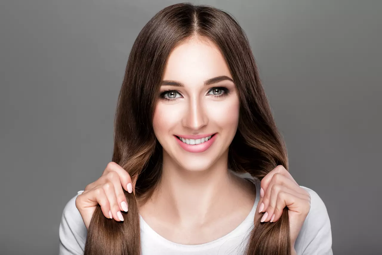 smiling beautiful brunette woman with shiny straight long hair. Care of  hair
