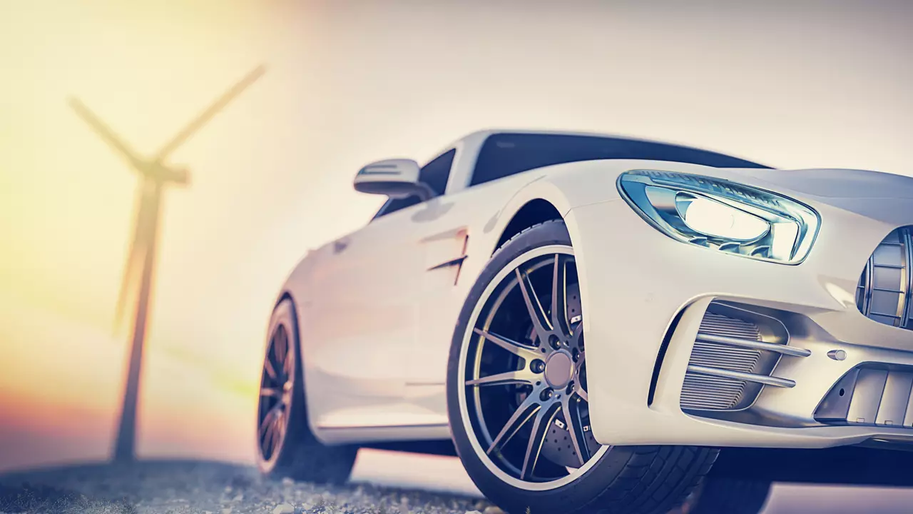 White sports car with a wind turbine in the distance