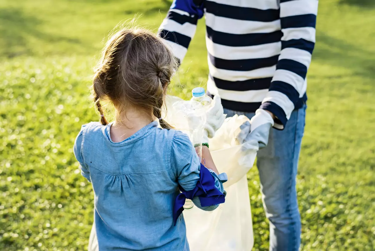 Young Girl Picking up Trash Outside in a Park