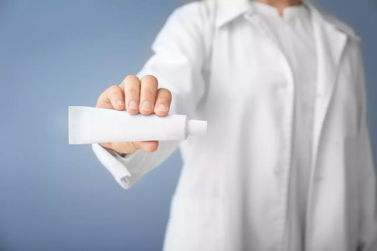 Dentist with toothpaste on color background
