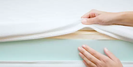 Woman's hands touching different layers of new mattress.      