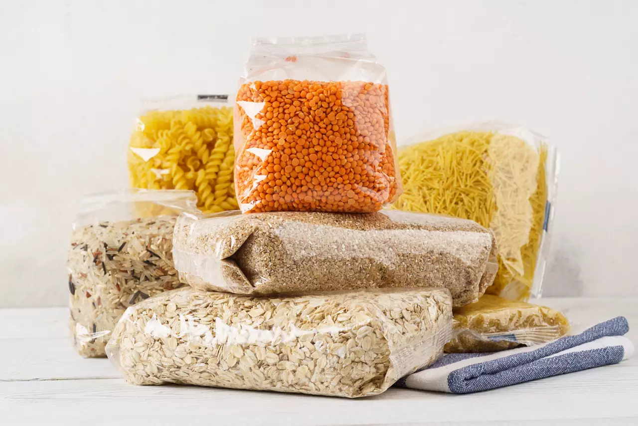 Various raw groats, cereal grains and pasta in plastic bags