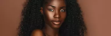 African beautiful woman portrait. Brunette curly haired young model with dark skin and perfect smile
