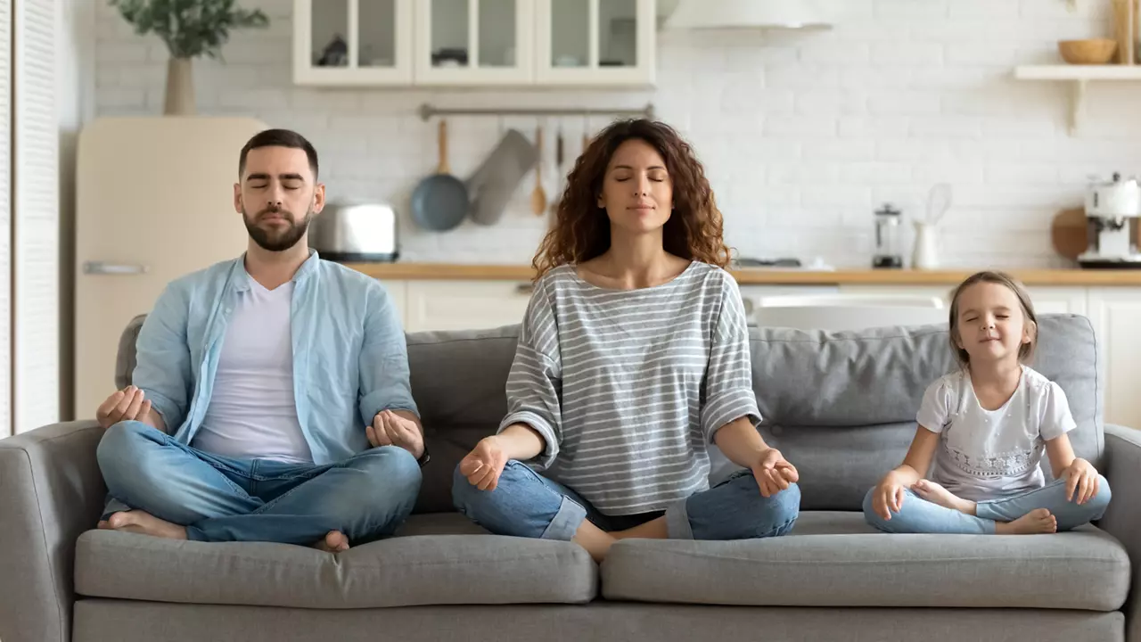 Family meditating on sofa