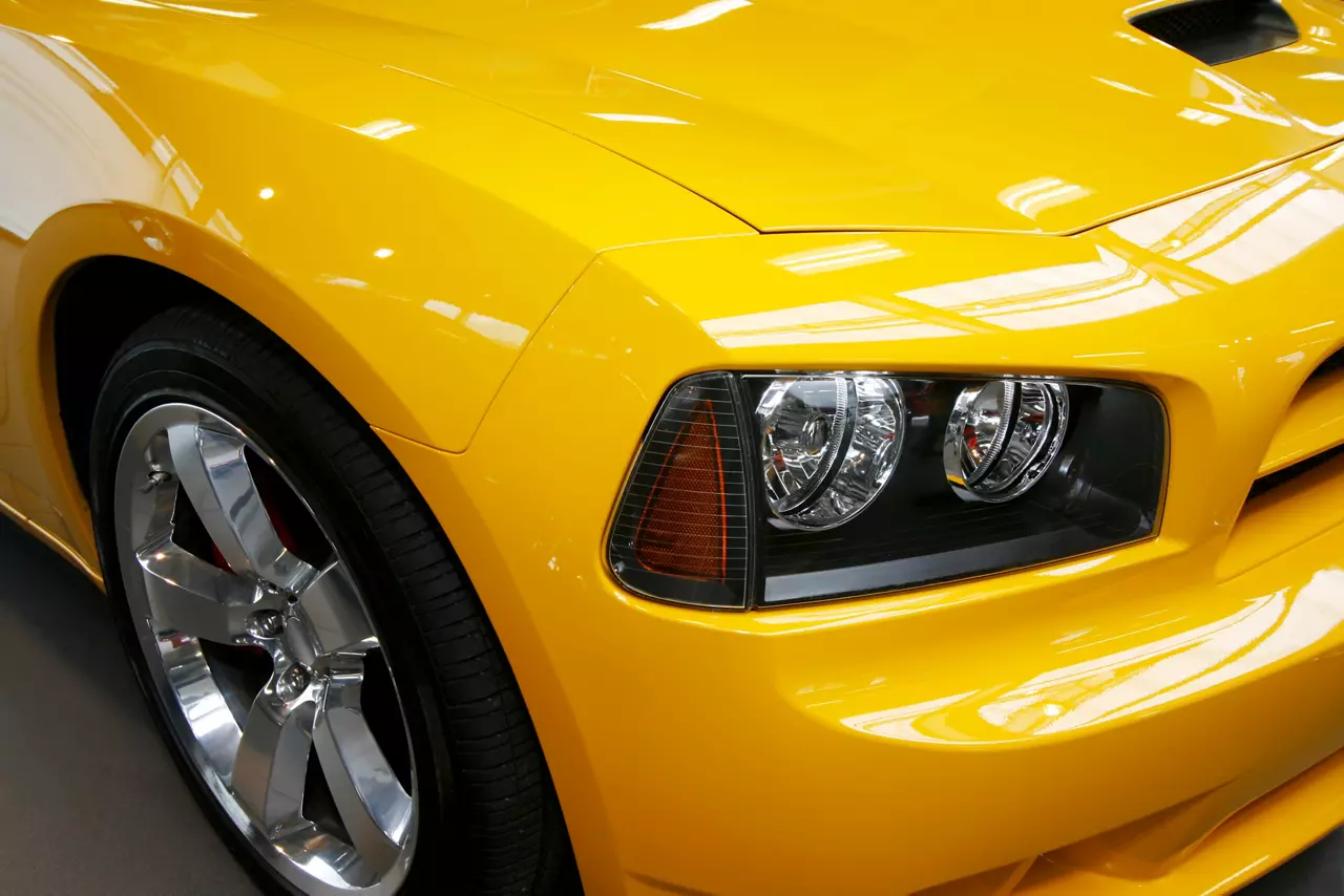 Close up of a yellow car headlight and front bumper