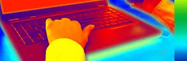 オフィス内のノートパソコンやスマートフォンの熱と輻射を示す赤外線サーモグラフィー画像