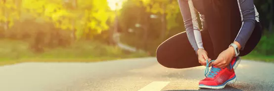 Female runner tying her shoes preparing for a run a jog outside