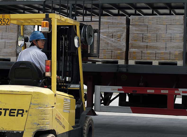 Fork lift operator loads a pallet on to a truck for delivery