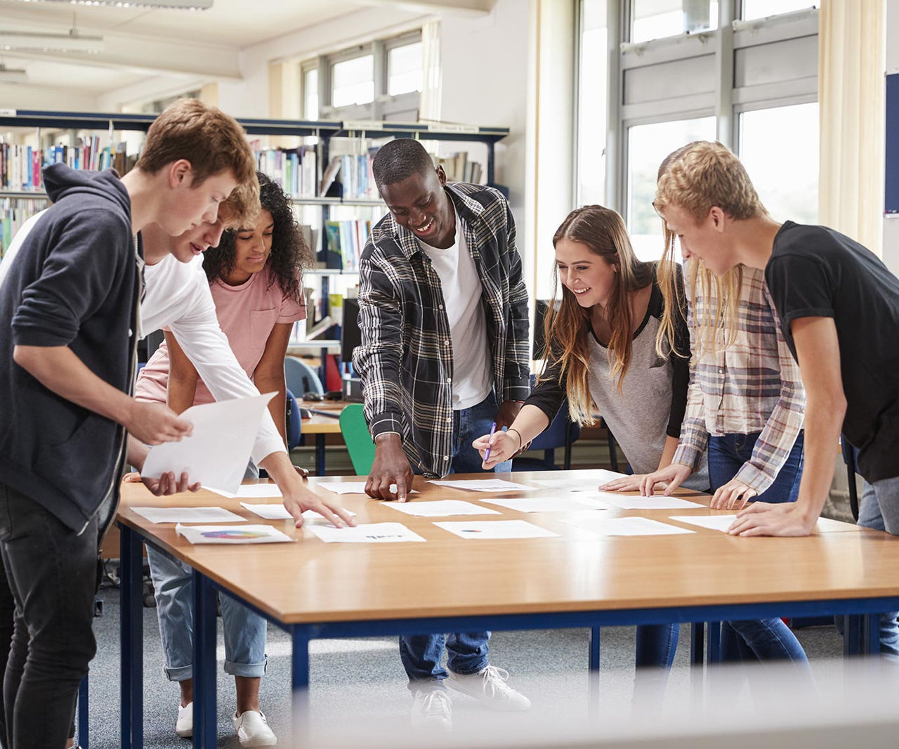 Group Of College Students Collaborating On Project In Library