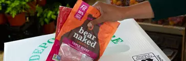 bear naked plastic packaging being placed in a Plastic Only recycle bin at the grocery store.