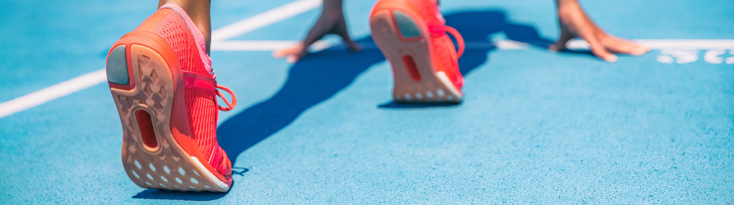 pink shoes on a runner at the starting line on the track