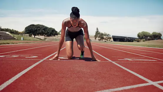 Fitness, running and woman at start line training for marathon race event at stadium. Exercise, sports and motivation for winning, black woman runner from Jamaica ready to run with focus and energy
